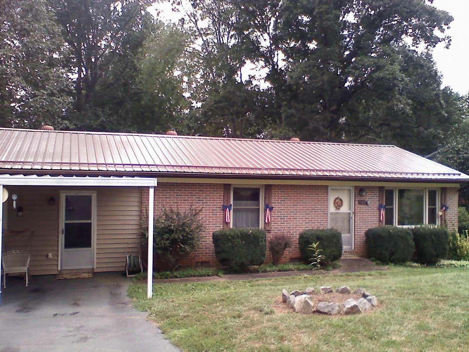 Bronze metal roof and carport on a brick ranch home — Roof Repair work by our crew in Brighton